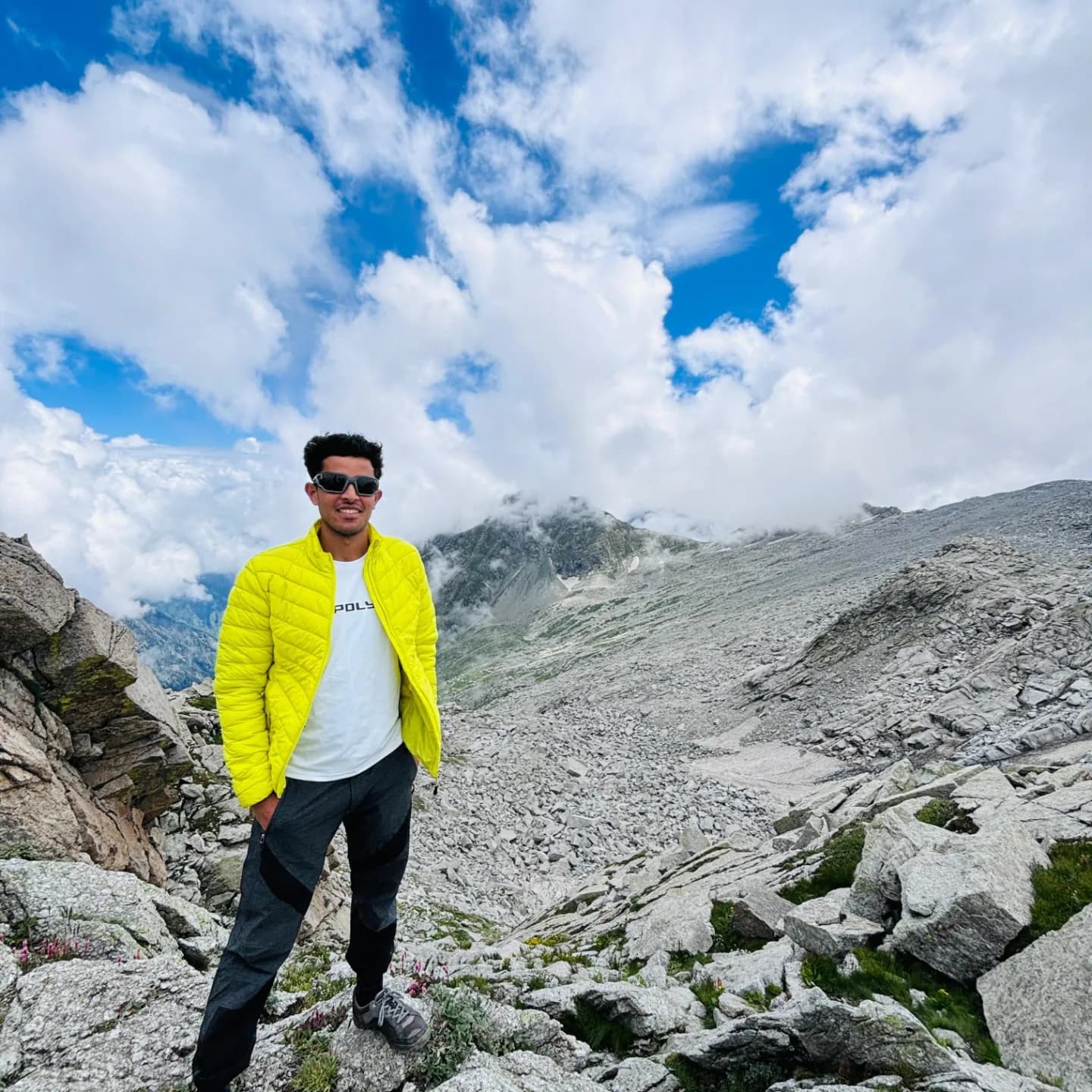 Hiker cresting a rocky ridge with high Himalayan peaks in the background